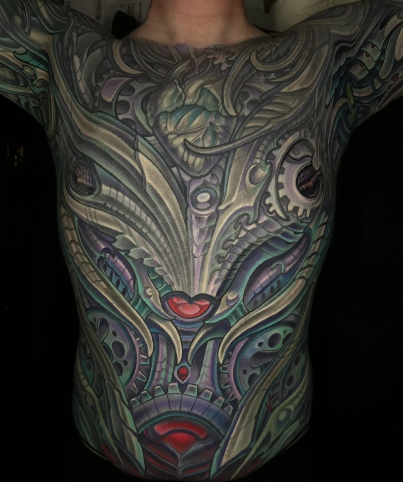 Biomechanical bodysuit tattoo, full front torso from throat to waist with gears and red accents by Terry Ribera at Remington Tattoo in San Diego.