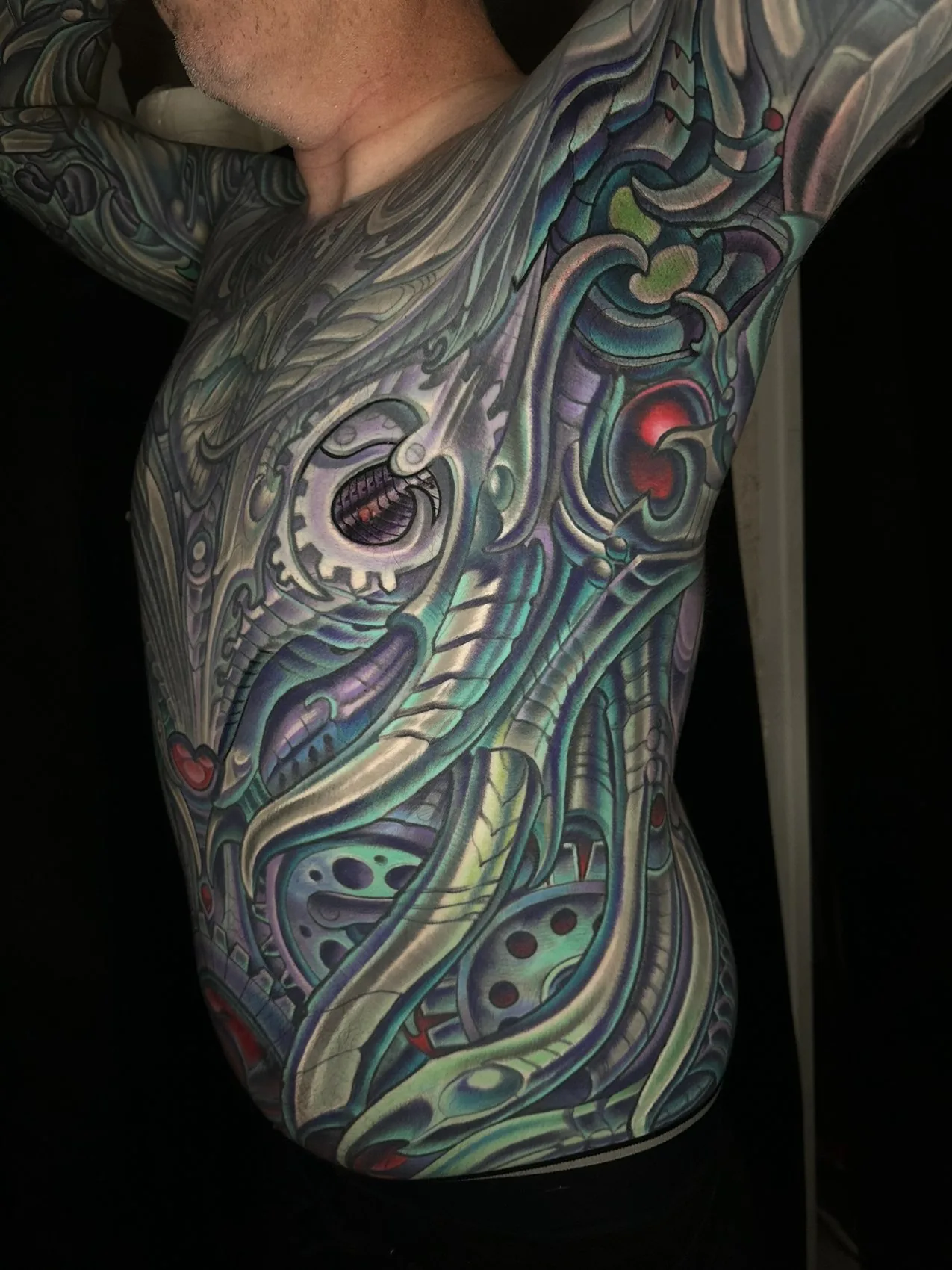 Biomechanical bodysuit tattoo, ribs and side torso with a mechanical eye detail by Terry Ribera at Remington Tattoo in San Diego.