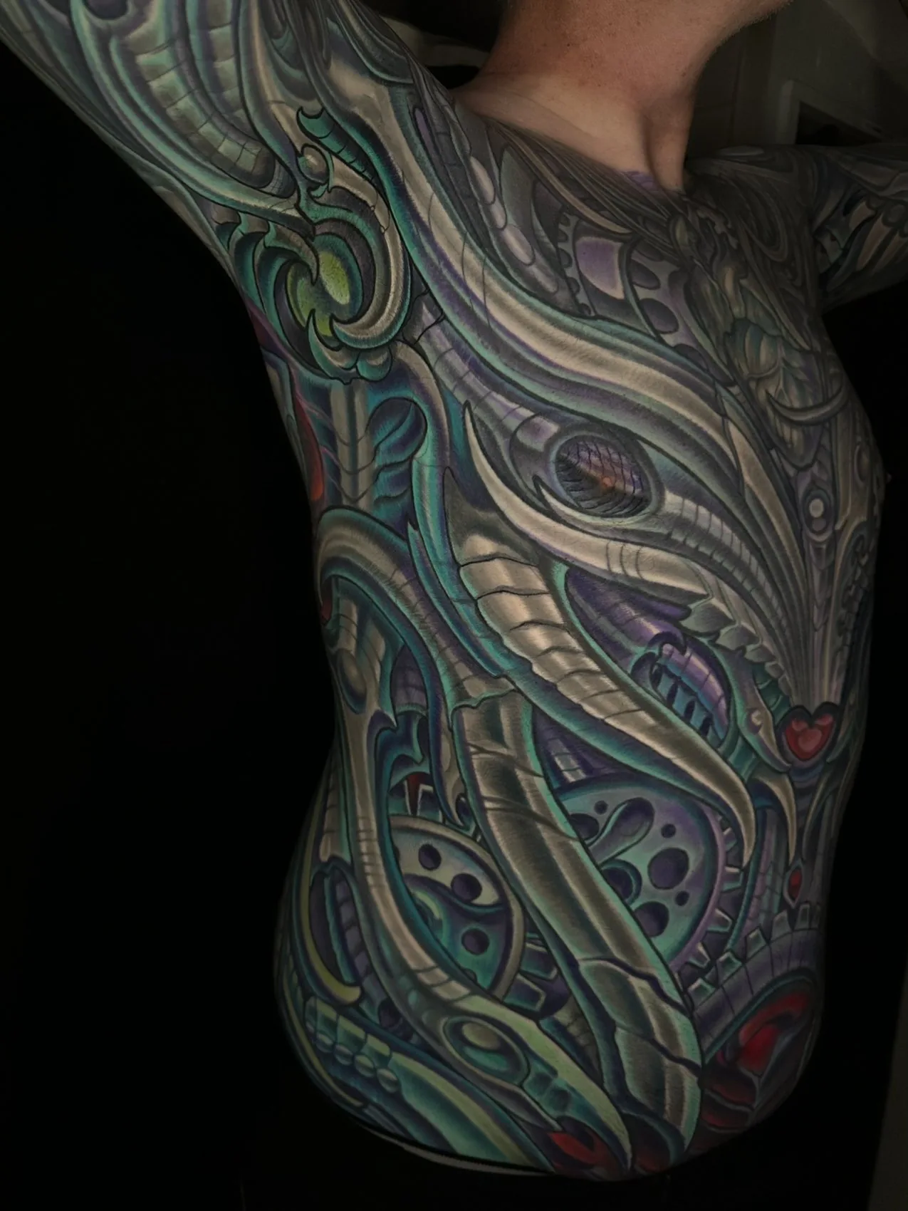 Biomechanical bodysuit tattoo, opposite ribs and side torso showing the design wrapping the body by Terry Ribera at Remington Tattoo in San Diego.
