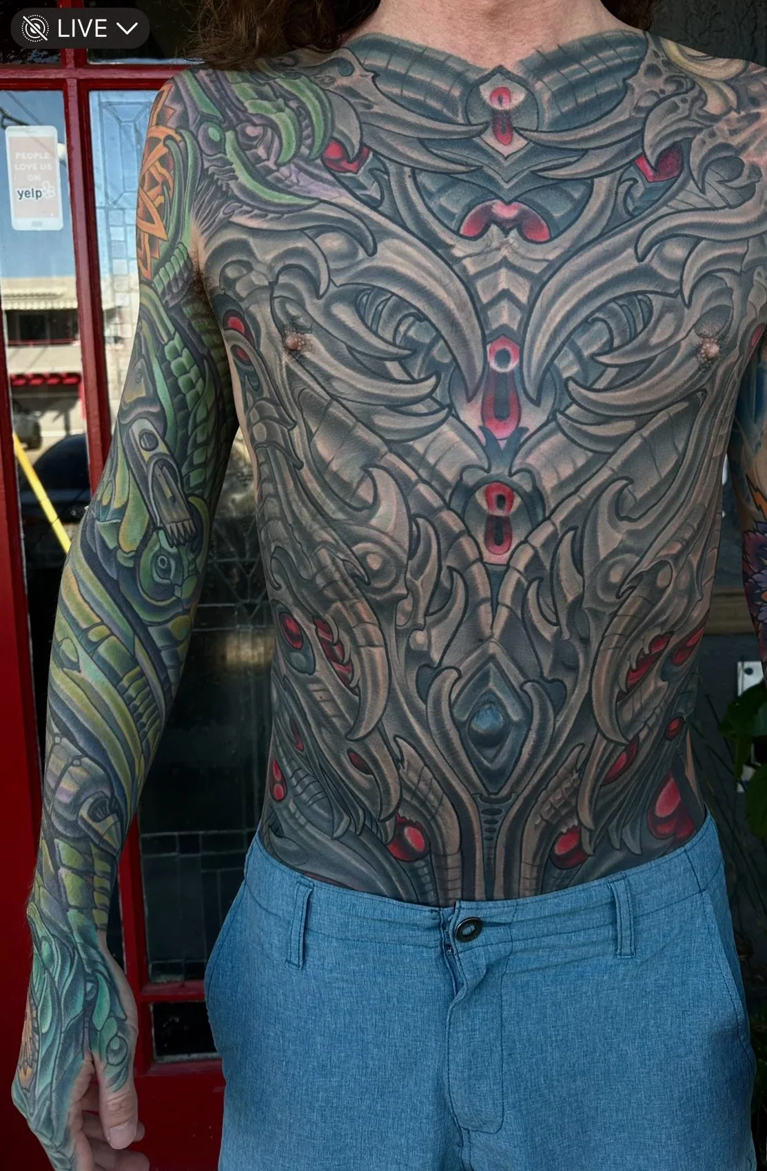 Biomechanical bodysuit tattoo, full front torso from collarbone to waist with red accents by Terry Ribera at Remington Tattoo in San Diego.