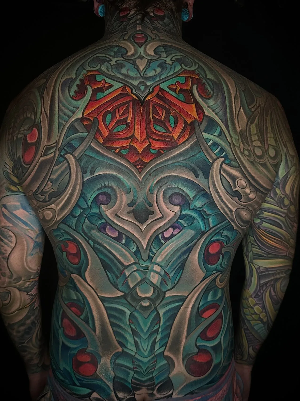 Biomechanical bodysuit tattoo, full back piece in green and teal by Terry Ribera at Remington Tattoo in San Diego.
