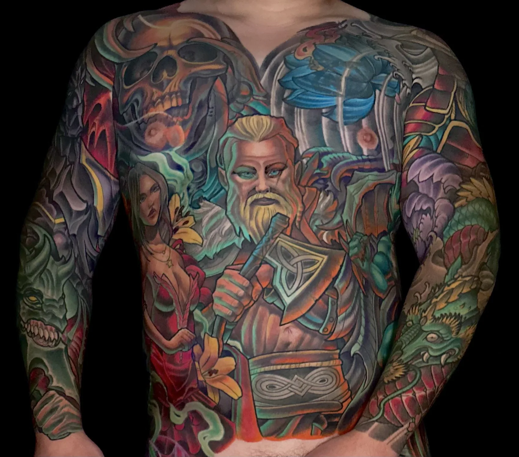 Fantasy illustrative bodysuit tattoo, chest piece with a bearded warrior, skull and dragon flanked by both sleeves by Terry Ribera at Remington Tattoo in San Diego.