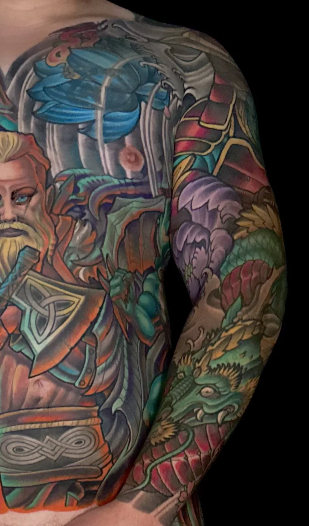 Fantasy illustrative bodysuit tattoo, right chest and arm detail with a green dragon and armored figure by Terry Ribera at Remington Tattoo in San Diego.