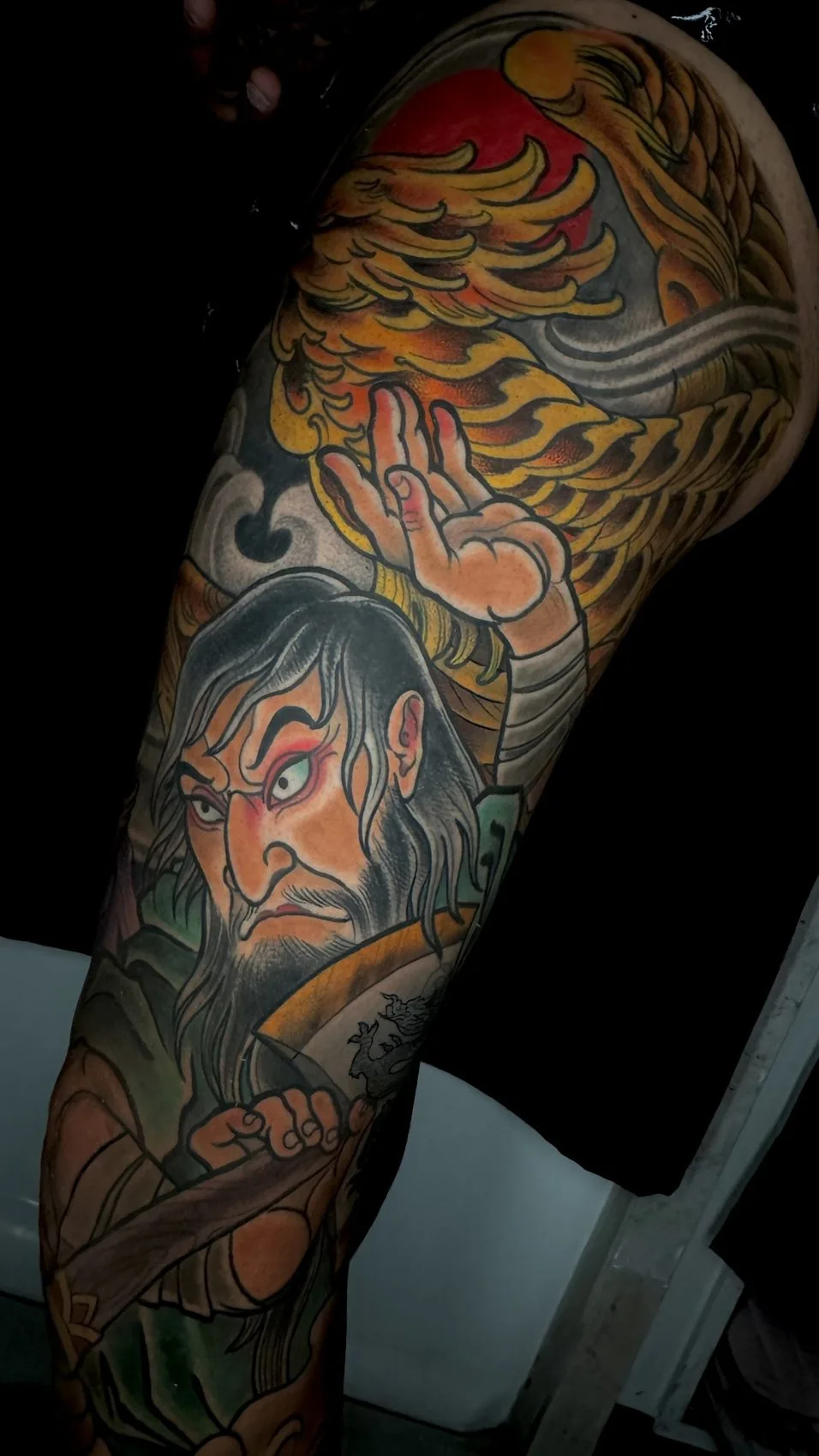 Neo Japanese color arm panel tattoo of a warrior figure below a phoenix and rising sun by Terry Ribera at Remington Tattoo in San Diego.