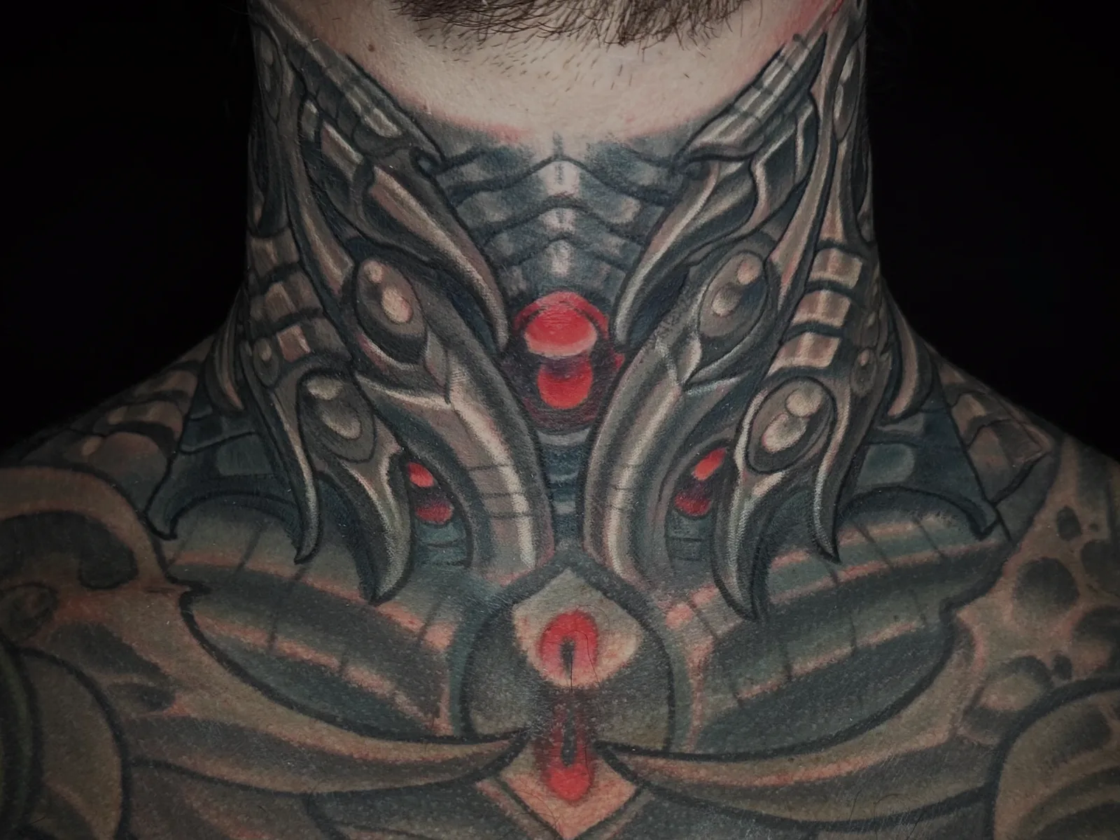 Black and grey biomechanical and bio-organic chest and neck tattoo by Terry Ribera, San Diego