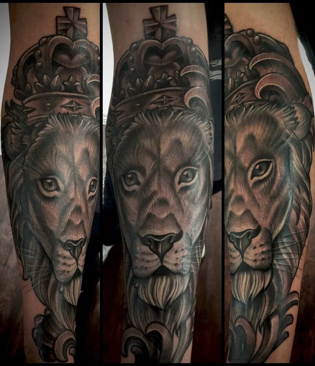Illustrative black and grey lion with crown forearm tattoo by Terry Ribera at Remington Tattoo, San Diego.